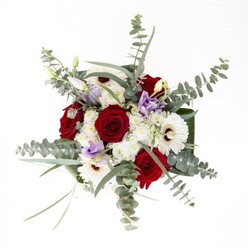 From the hands of an experienced Harefield florist, this bouquet exudes quiet confidence and natural harmony, much like a walk across Harefield Moor on a bright morning. The creamy, sunlit gerberas with their espresso centers form calming anchors, surrounded by deep red roses whose spiralled forms suggest enduring affection and care. Wisps of eucalyptus dance above, casting shifting shadows and lending silvery-green highlights-a nod to the cool, fresh air that drifts down Park Lane in Harefield. Lilac lisianthus, thoughtfully scattered through the bouquet, offers a dreamy, contemporary accent, their delicate petals reminiscent of the purple haze seen in local wildflower meadows at dusk. The arrangement brims with volume and softness thanks to clusters of cloud-like white filler blooms and generous foliage. Framing the composition, luxurious dark green leaves wrap the stems, offering structure and a professional finish. Water refracts through the glass vase, signalling the bouquet's vitality and farm-fresh pedigree. The result is an evocative piece celebrating artistry and seasonal abundance, ideal whether marking a birthday on Rickmansworth Road, comforting a friend, or elevating daily life with a touch of natural splendour, brought thoughtfully to your door by Harefield Florist.