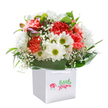 A sense of lighthearted celebration radiates from this expertly crafted Harefield bouquet-an arrangement that seems to capture the freshness of morning walks along Breakspear Road and the promise of shared moments. At its core, soft coral and peach carnations bloom with rich, frilled petals, their colour warmed by subtle notes of dusk. Interspersed are snowy white daisies beaming with golden-green centers, their presence uplifting and bright. Wispy trails of baby's breath drift between the blossoms like tiny clouds, imbuing the bouquet with innocence and softness. Encircling the flowers, deep green, shiny leaves fan outward, cradling the arrangement with a nurturing embrace reminiscent of cherished gardens in Harefield. Here and there, unopened buds tinged with purple hint at blooms yet to arrive, bringing an element of gentle anticipation. The pristine white gift bag, designed for easy carrying with its satin ribbon handles, nestles the bouquet perfectly, set against a clean white backdrop that showcases every joyful detail. Suitable for birthdays, new beginnings, or to express care on any occasion, this stunning bouquet is a testament to the artistry of Harefield Florist, echoing the heartfelt warmth and vibrant spirit found within the local community.